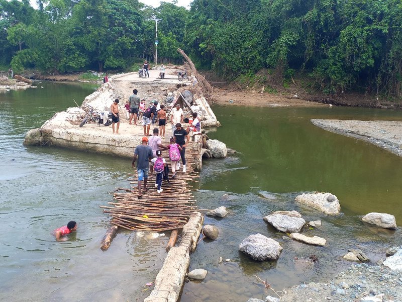 El río Camú se cruza usando un puente de palitos